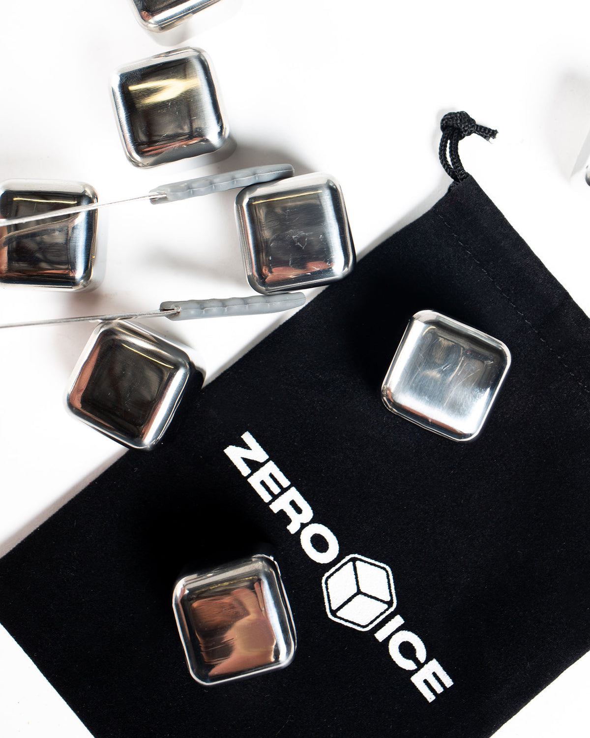 Zero Ice stainless steel cubes on a black cloth with brand logo